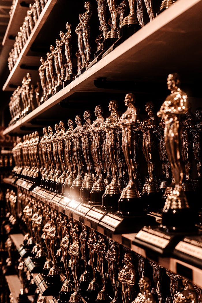 our-story Close-up image of numerous golden trophy awards neatly arranged on shelves.